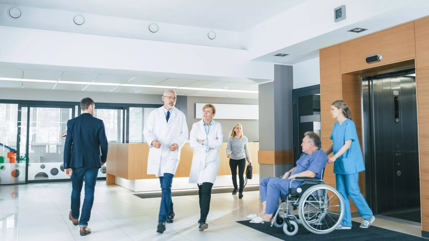 Doctors with patient in corridor